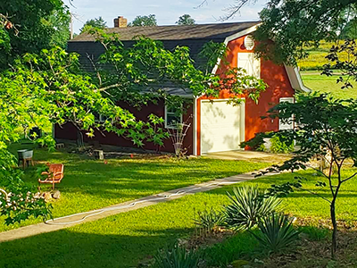 Polk County Painter example of work: beautiful painted barn in well-kept landscape of trees and lawn
